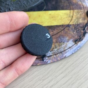 A circular black plastic dial with a textured surface and a grooved edge.