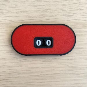 An oblong, red, textured counter device with a black border.