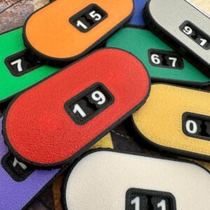 A collection of oval-shaped plastic counters in various colours including red, orange, yellow, green, purple, and white.