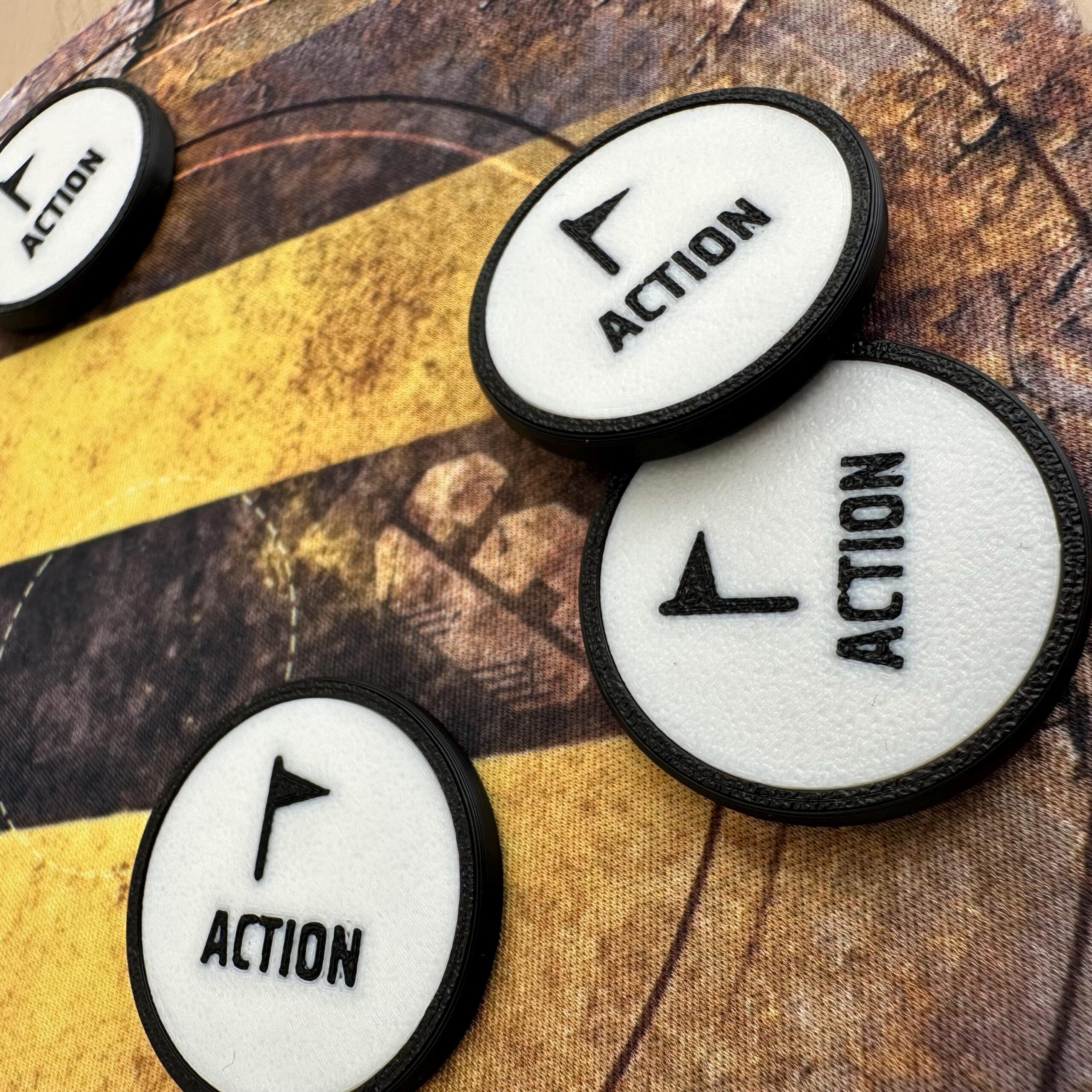 Four circular game tokens with a white textured surface and a black border.