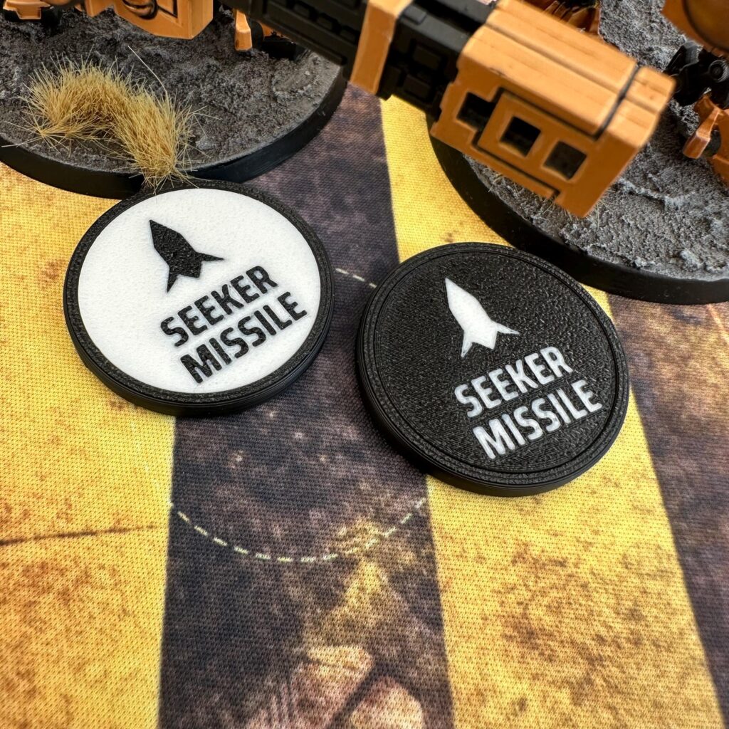 Two circular game tokens with black rims.